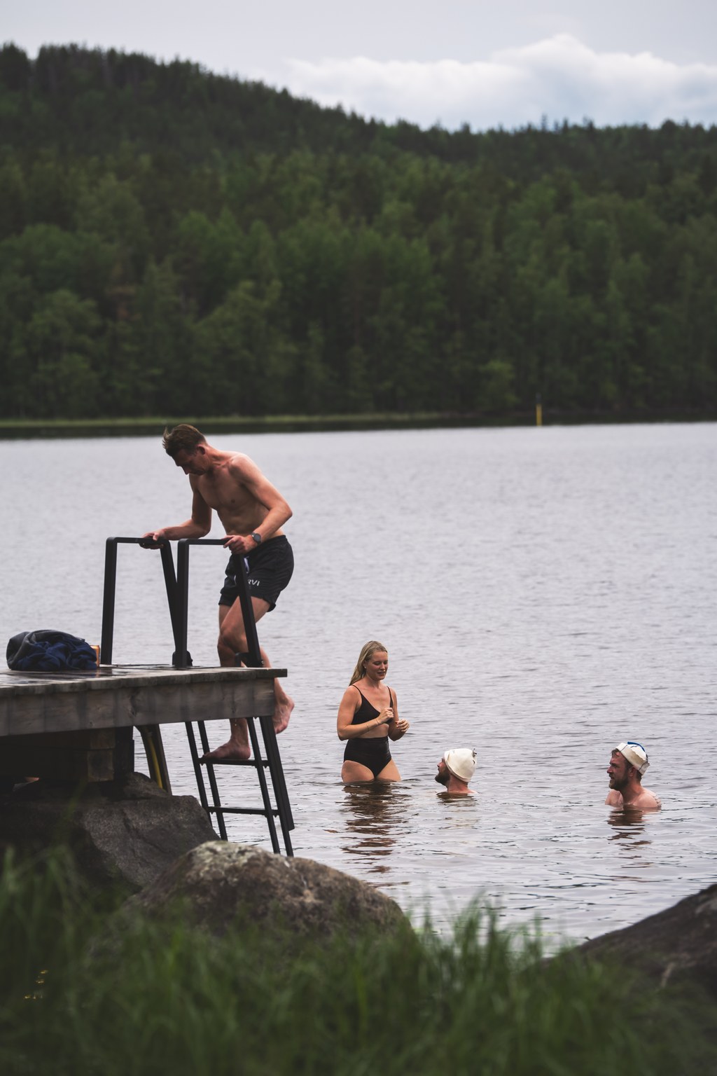 Neljä henkilöä uimassa saunan jälkeen
